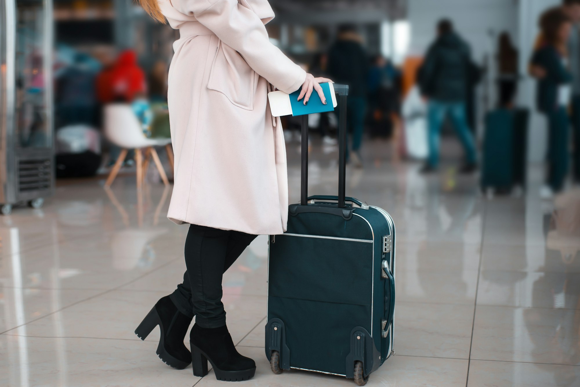 Legs of businesswoman with baggage in airport.